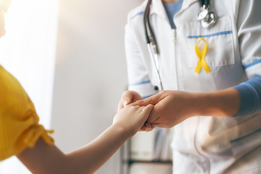 World Childhood cancer Day. Girl patient listening to a doctor in medical office.